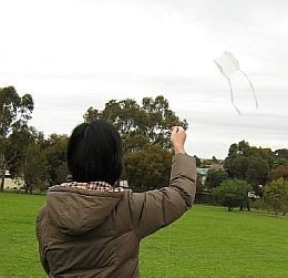 My wife May flying a clear plastic 1-Skewer Sled kite.