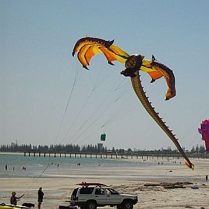 Elaborate inflatable dragon kite in flight.