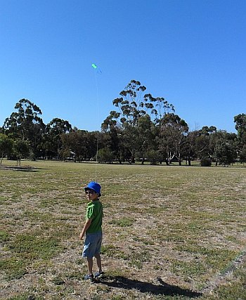 A 5 year-old flying a small sled kite. A 5 year-old flying a small sled kite.